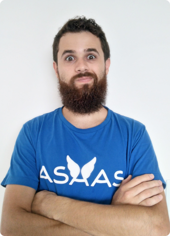 Homem branco, com barba e a camiseta azul do Asaas.